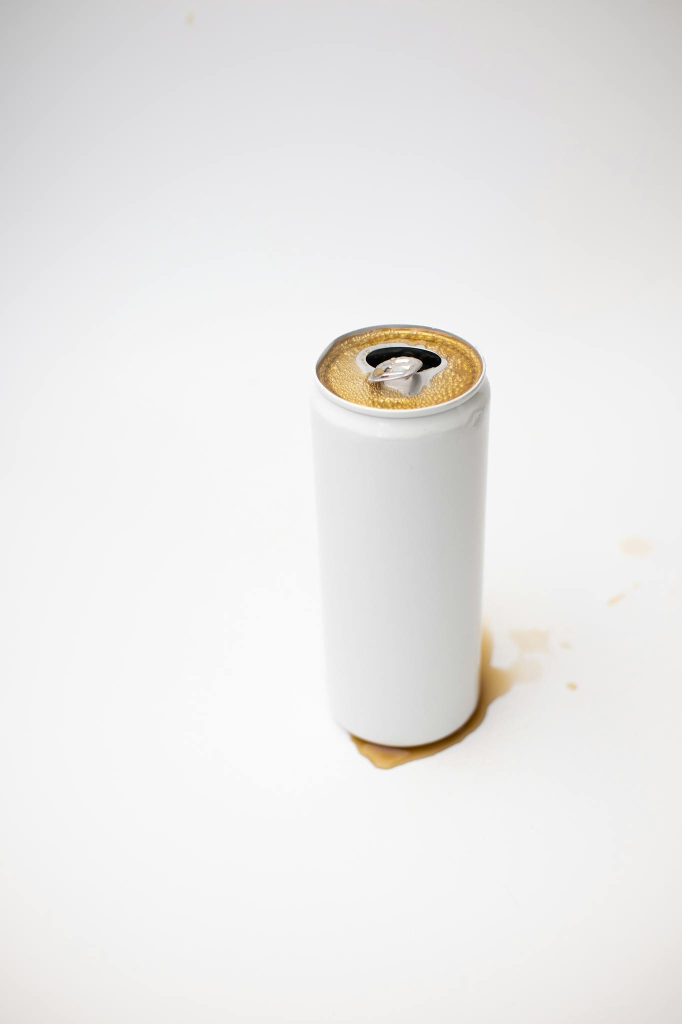 A white soda can with spilled beverage on a clean surface, representing simplicity and minimalism.